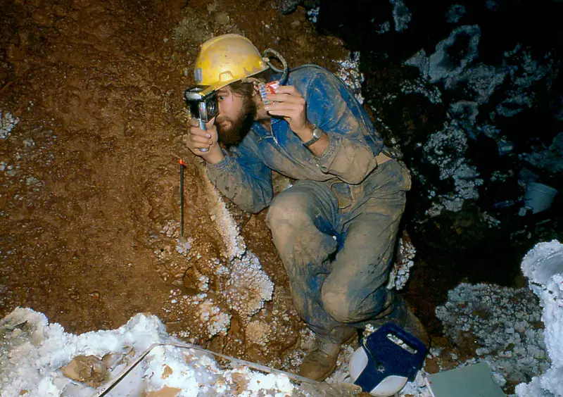 Dave Crombie surveying in stream passage under Krakatoa Cango